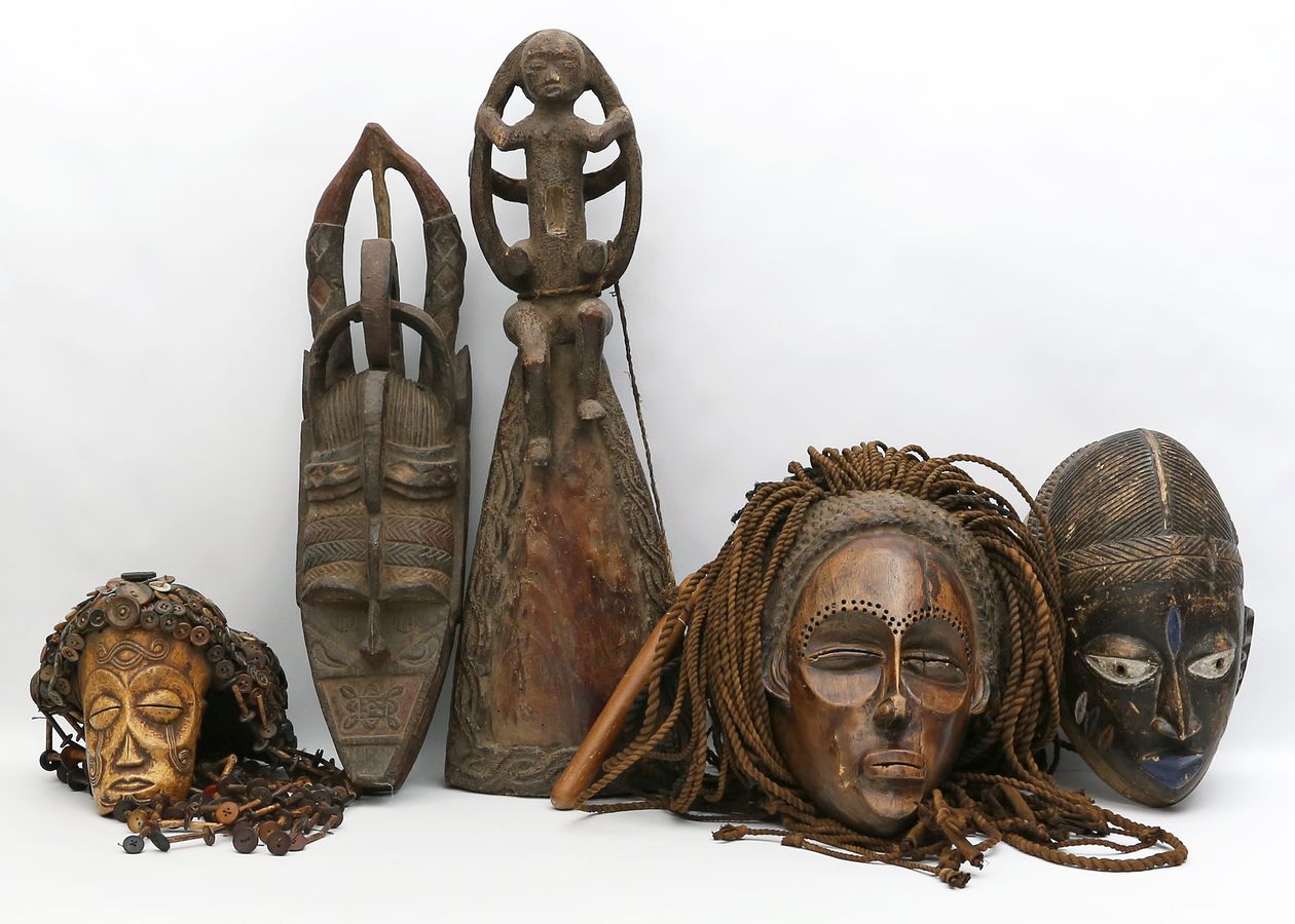 Vier afrikanische Masken und Klanginstrument.