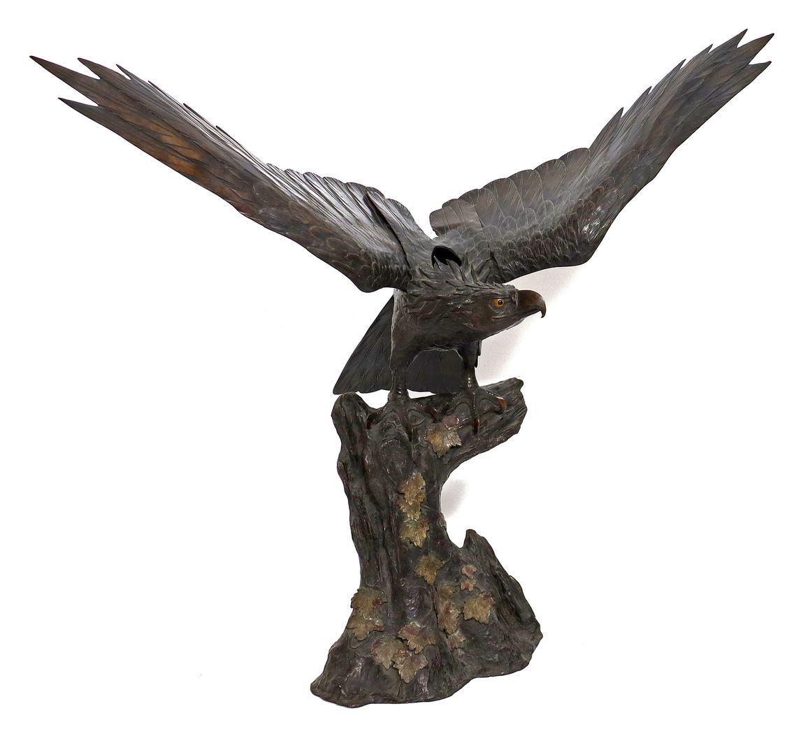 Lebensgroße Skulptur eines Adlers auf Baumstumpf.