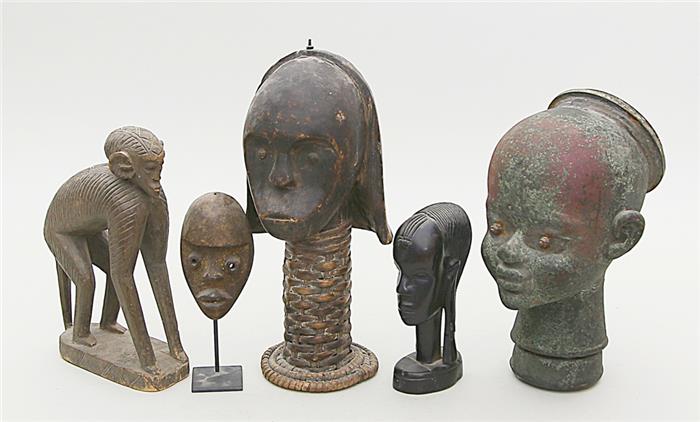 Vier afrikanische Masken und Affenskulptur.